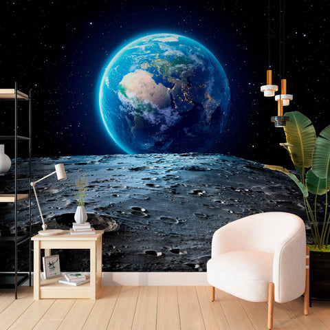 Earth from the moon wallpaper in a reading corner with a white armchair.