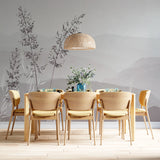 A serene minimalist wallpaper featuring delicate grass silhouettes against a soft, misty mountain backdrop in muted gray tones.