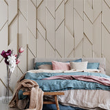 A minimalist geometric wallpaper featuring a repeating pattern of overlapping diamond shapes in a neutral beige tone.