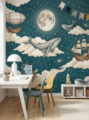 Dark teal whale wallpaper mural with full moon, stars, constellations, clouds, vintage airship and sailing ship in a kids bedroom.