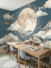 Dark teal whale and moon wall mural displayed behind a cozy children’s bed with warm wood details and blue bedding.