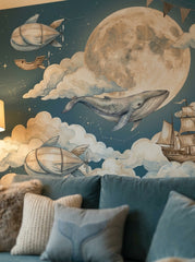 Whale moon wallpaper mural with flying whales, airships, clouds, constellations and sailing ship in a kids study room.
