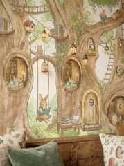 Whimsical treehouse wallpaper mural with woodland animals, giant trees, rope bridges and reading nooks in a colorful kids playroom.