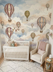 Dreamy balloon nursery wallpaper with soft watercolor clouds, vintage hot air balloons, white crib and rocking chair.