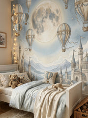 Fairytale castle nursery wallpaper featuring vintage hot air balloons, moon, clouds and soft blue celestial sky.