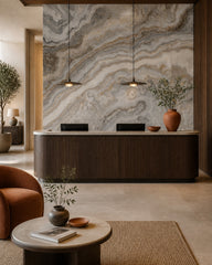 Gray onyx & amber veins stone wall mural at a hotel reception desk.