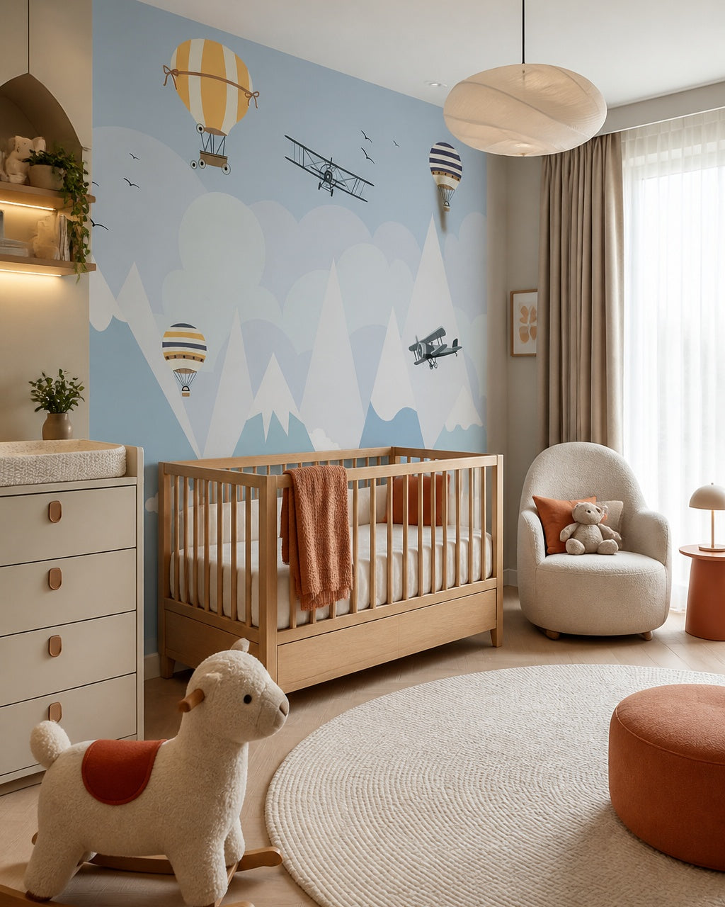 Airplanes and balloons over the mountains nursery wallpaper in a modern nursery with a crib.