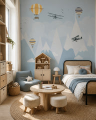 Airplanes and balloons over the mountains nursery wallpaper in a girl’s bedroom.