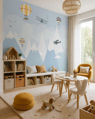 Airplanes and balloons over the mountains nursery wallpaper in a children’s playroom.