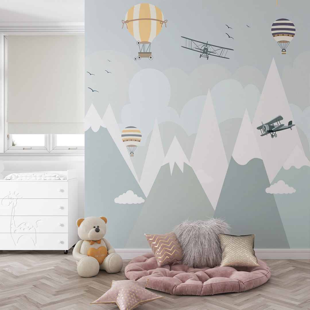 Aviation nursery wallpaper displayed in a cozy kids room with vintage airplanes, striped balloons, clouds, birds, and snowy mountains.