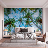 Upward View of Palm Trees Against Blue Sky Wall Mural Wallpaper