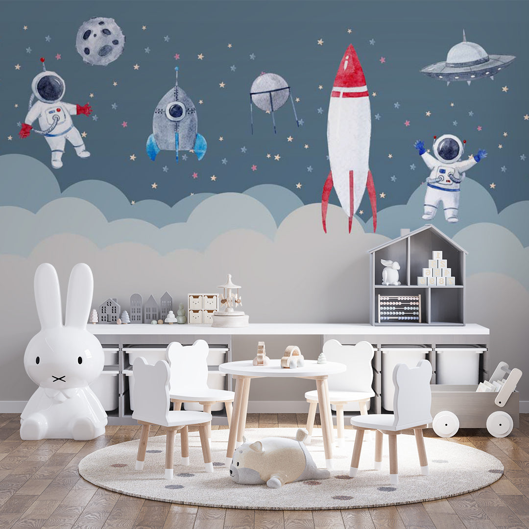 Watercolor kids room wallpaper with floating astronauts, colorful rockets, satellites, a flying saucer, moon, stars, and clouds.