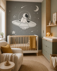 Astronaut in a flying saucer space wall mural in a modern nursery with a crib.