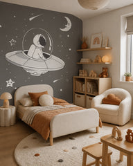 Astronaut in a flying saucer space wall mural in a toddler bedroom with a child-sized bed.