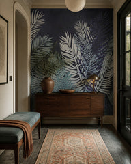 Dark navy palm leaves wallpaper in a refined foyer.