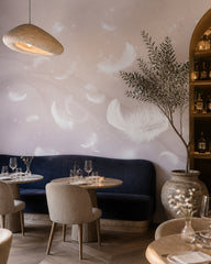 White feathers on lilac wallpaper in a restaurant.