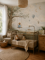 Woodland kids wallpaper with boy on swing, leafy tree, blue balloons and peaceful mountain scenery in a natural nursery interior.