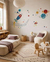 Colorful rocket, planets & stars space wall mural in a toddler bedroom with a child-sized bed.