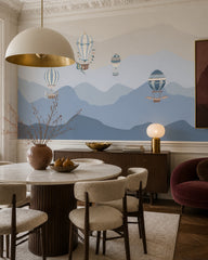 Vintage balloons over blue mountains wallpaper in a refined dining area.