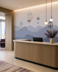 Vintage balloons over blue mountains wallpaper at a hotel reception desk.