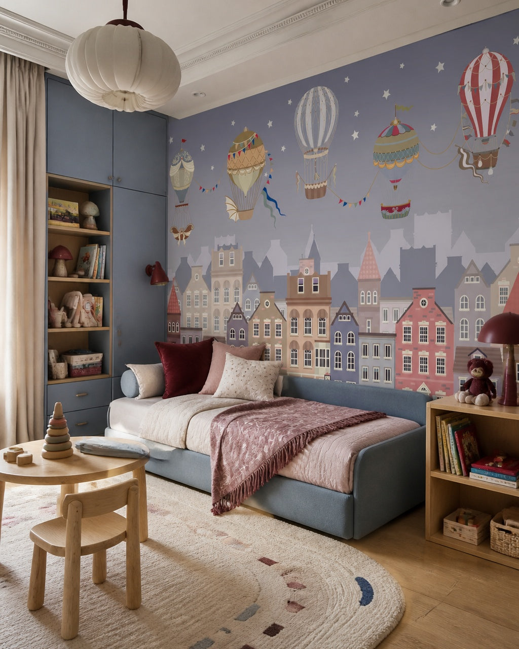 Vintage balloons over the twilight town wallpaper in a toddler bedroom with a child-sized bed.