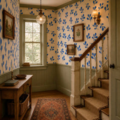 Cobalt blue botanical wallpaper with repeating hand-painted leaf pattern in a warm modern kitchen.