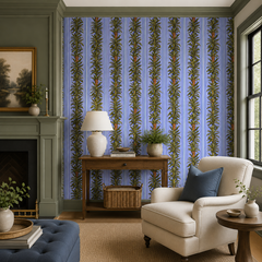 Blue stripe botanical wallpaper in a living room with green fireplace and cream armchair.