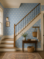 Powder blue daisy wallpaper along a staircase with wooden railing.