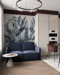 Blue tropical leaves wallpaper behind a navy sofa in a modern studio apartment.