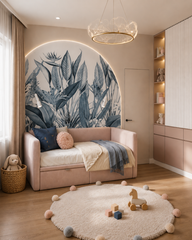Blue tropical leaves wallpaper in an arched niche in a girls’ room with pink daybed.