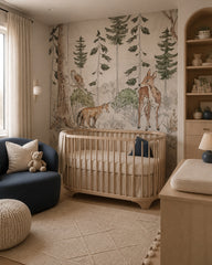 Vintage woodland wallpaper in a modern nursery with a crib.