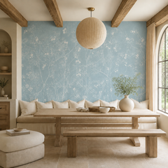Dusty blue chinoiserie blossom wallpaper in a dining nook with banquette and wooden beams.