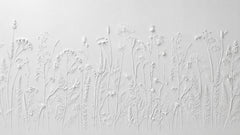 White wallpaper with a 3D embossed effect of wildflowers and grasses resembling sculpted plaster.
