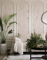 Beige meadow grass wallpaper within arched wall moldings in a living room.