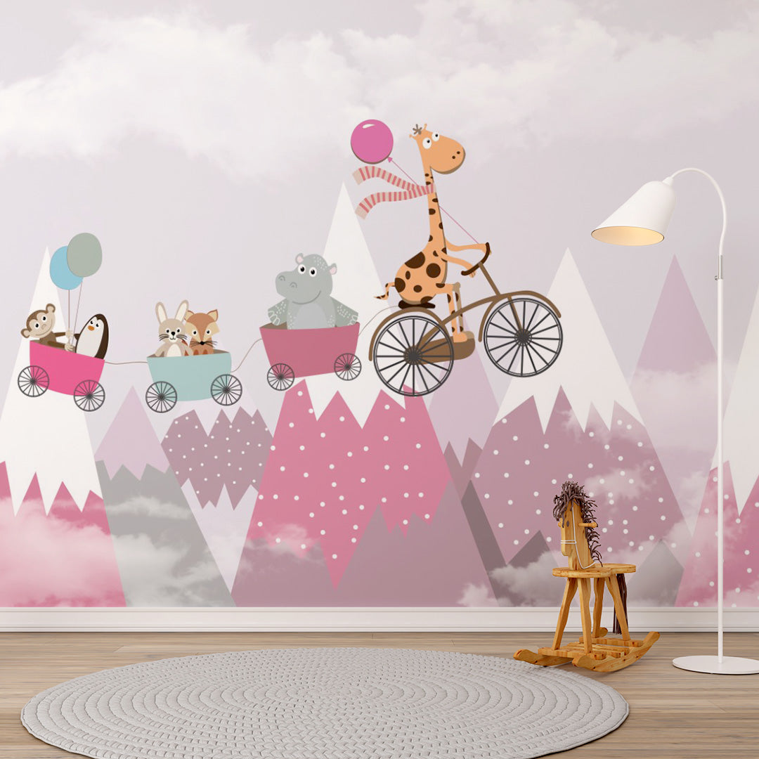 Pink kids room wallpaper with a giraffe riding a bicycle and pulling animal friends in carts above misty snow-capped mountains.