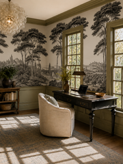 Black and white Italian toile wallpaper in a study with olive green trim and antique desk.