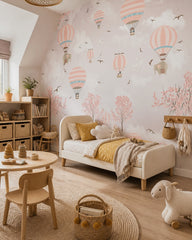 Pink sky hot air balloons wallpaper in a toddler bedroom with a child-sized bed.