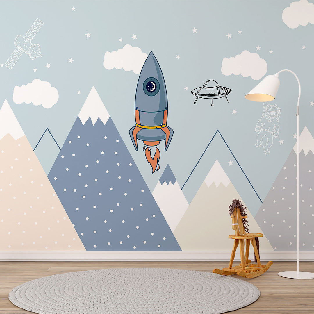 Blue kids room wallpaper with a rocket, astronaut, satellite, flying saucer, stars, clouds, and geometric mountains.