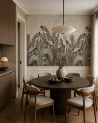 Grey banana leaves wallpaper in a refined dining area.