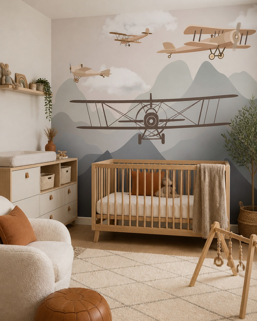 Vintage airplanes over the mountains kids room wallpaper in a modern nursery with a crib.