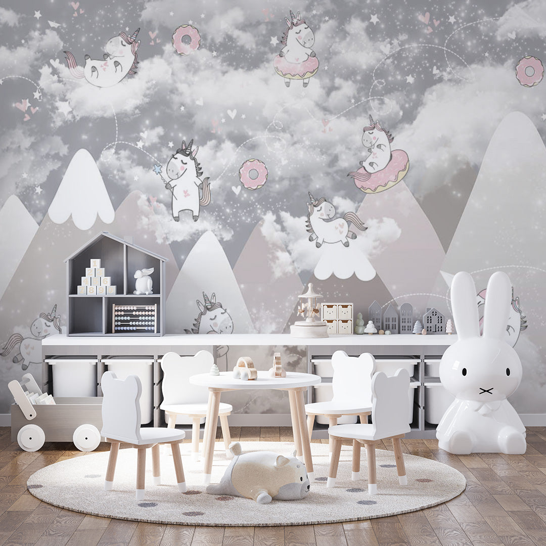 Pastel nursery wallpaper with playful unicorns, pink donuts, pool rings, clouds, stars, paper airplanes, and snowy mountains.