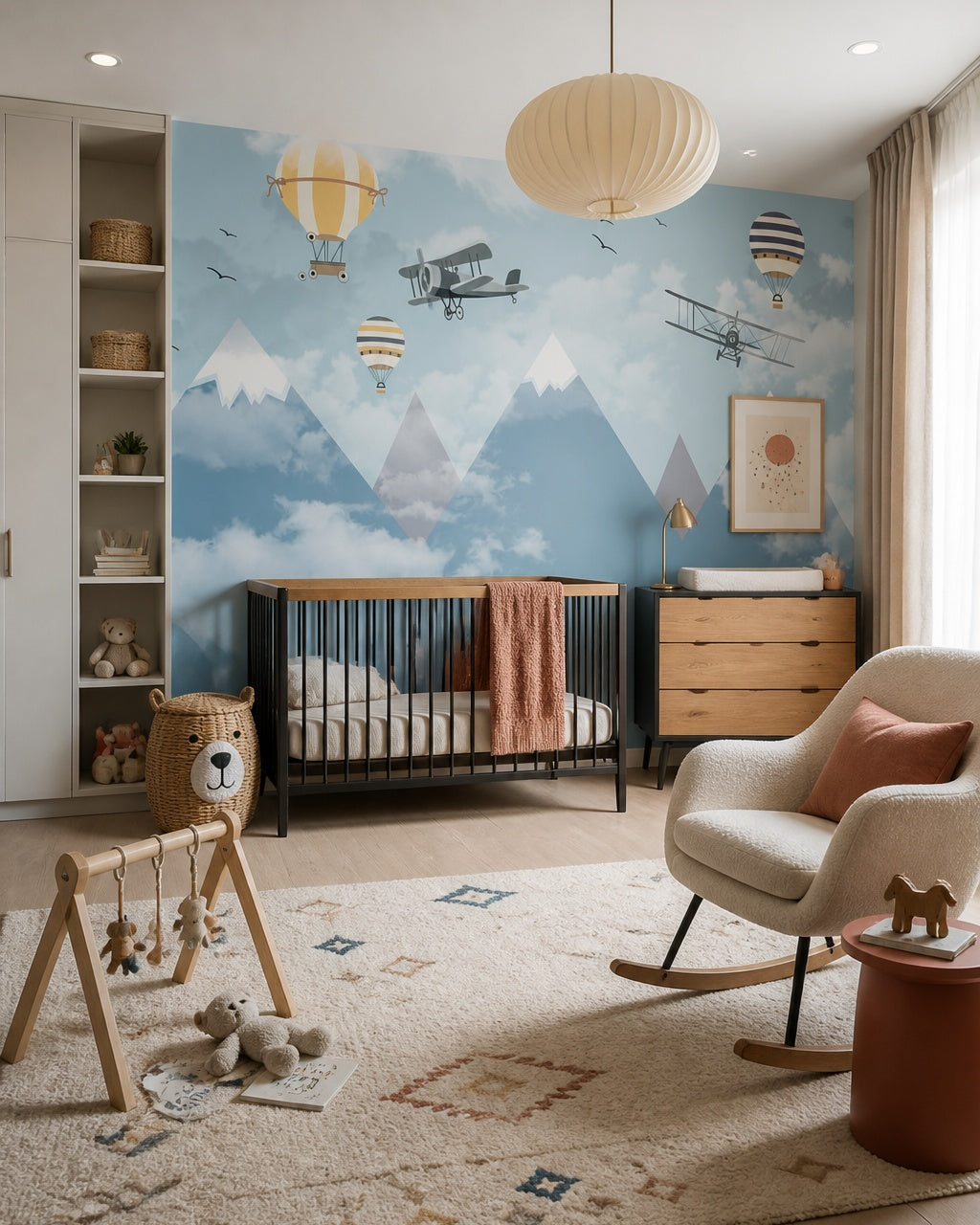 Vintage flights above misty mountains wallpaper in a modern nursery with a crib.