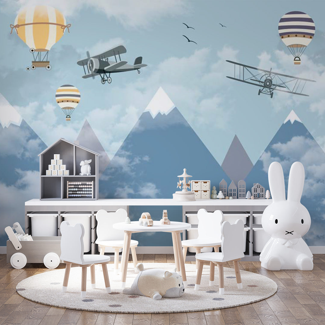 Blue kids room wallpaper with vintage biplanes and striped hot-air balloons flying above snowy mountains and misty clouds.