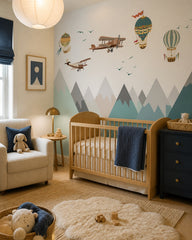 Vintage airplanes and balloons over mountains wallpaper in a modern nursery with a crib.