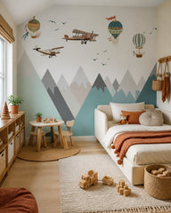 Vintage airplanes and balloons over mountains wallpaper in a toddler bedroom with a child-sized bed.