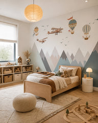 Vintage airplanes and balloons over mountains wallpaper in a boy’s bedroom.