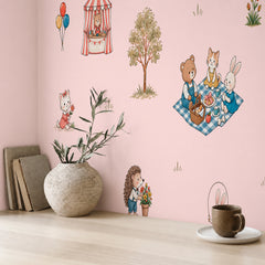 Pink nursery wallpaper with cute animal characters displayed behind a white crib in a soft neutral baby room.