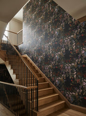 Dark botanical bouquet wallpaper on a staircase wall.