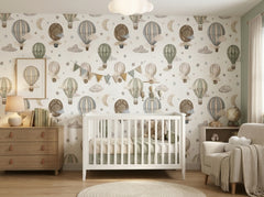 Hot air balloon wallpaper in a personalized nursery with white baby crib, moon, stars and vintage balloon pattern.