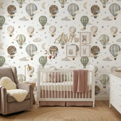 Vintage balloon wallpaper displayed in a warm nursery with classic crib, pink armchair and neutral children’s decor.